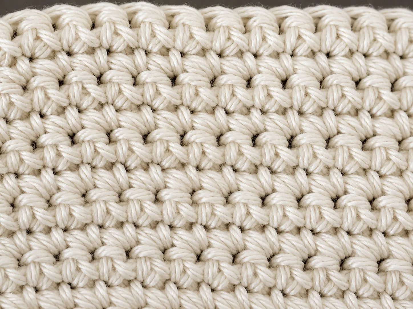 Close-up of a cream single crochet swatch showing dense, even columns of V-shaped stitches.